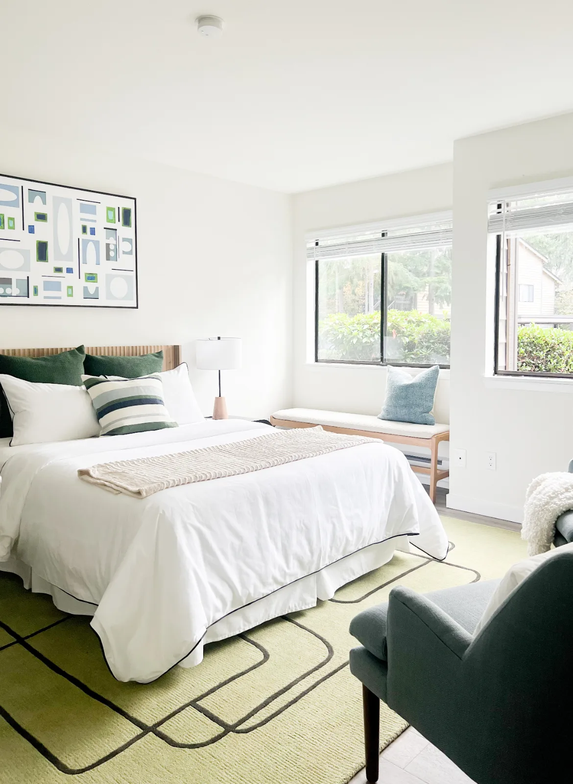 The Park in Bellevue: Bright bedroom with layered linens and green geometric rug