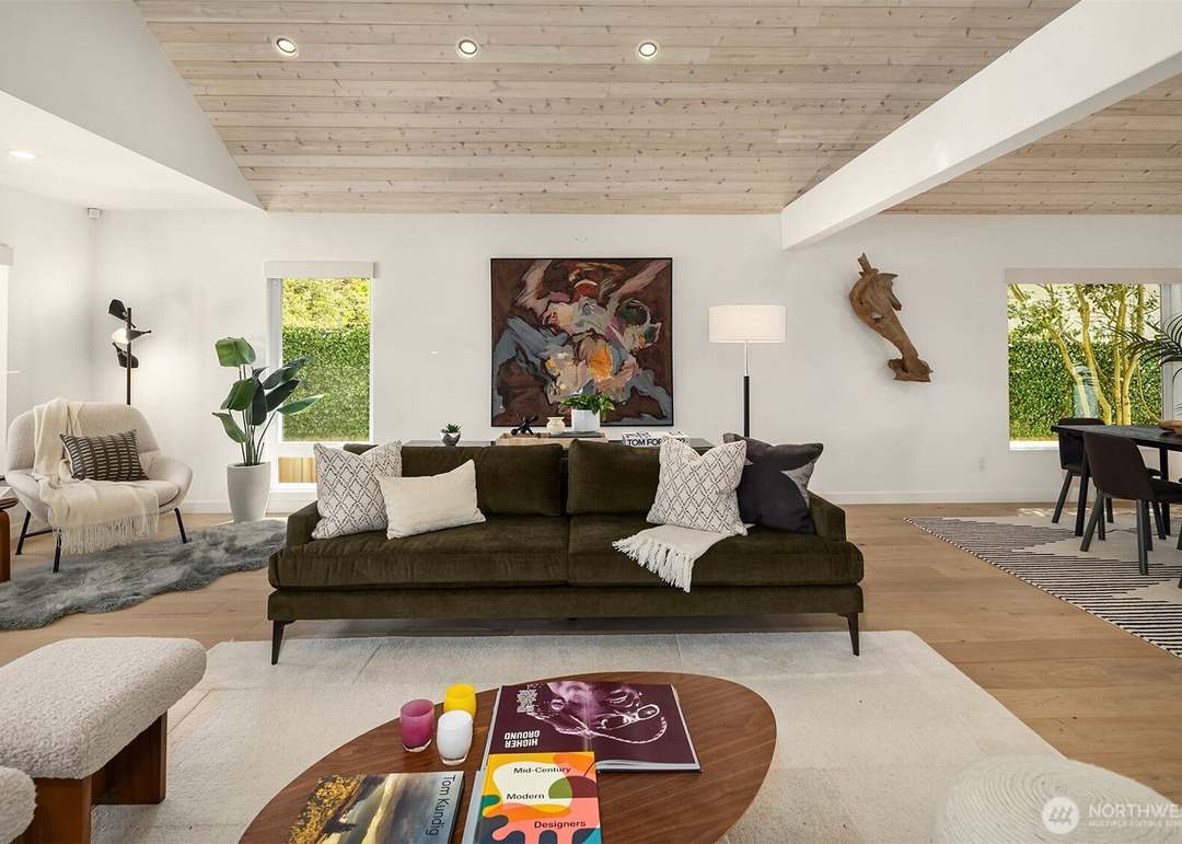 Contemporary living room with olive green velvet sofa under a vaulted wood ceiling