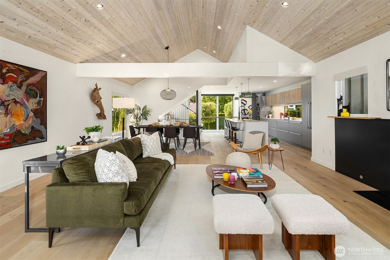 Open-concept living area with olive green velvet sofa and vaulted ceiling