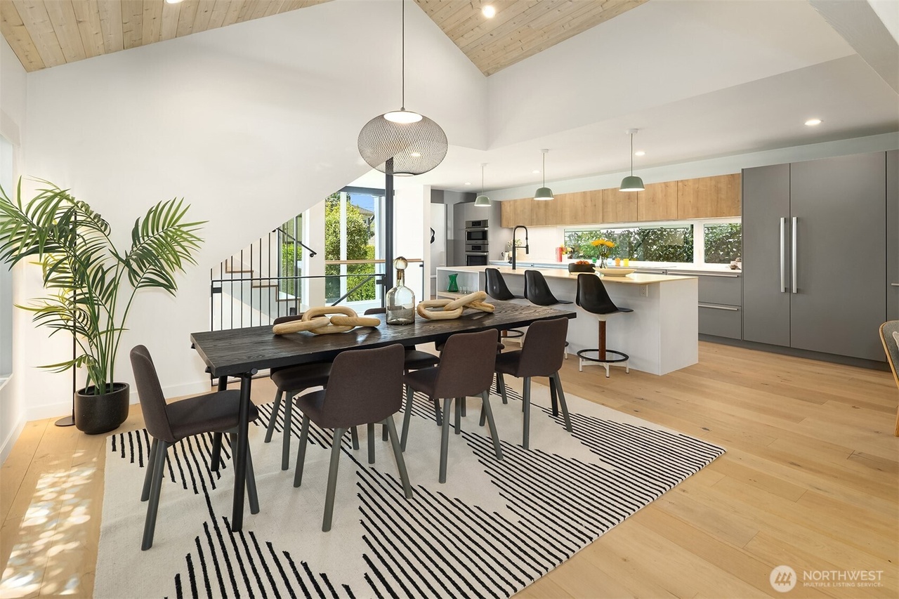 Dining and kitchen space with geometric rug and vaulted wood ceiling