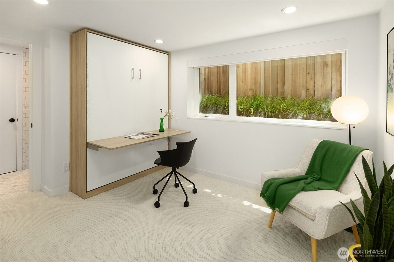 Guest room with fold-out Murphy bed, integrated desk, and armchair