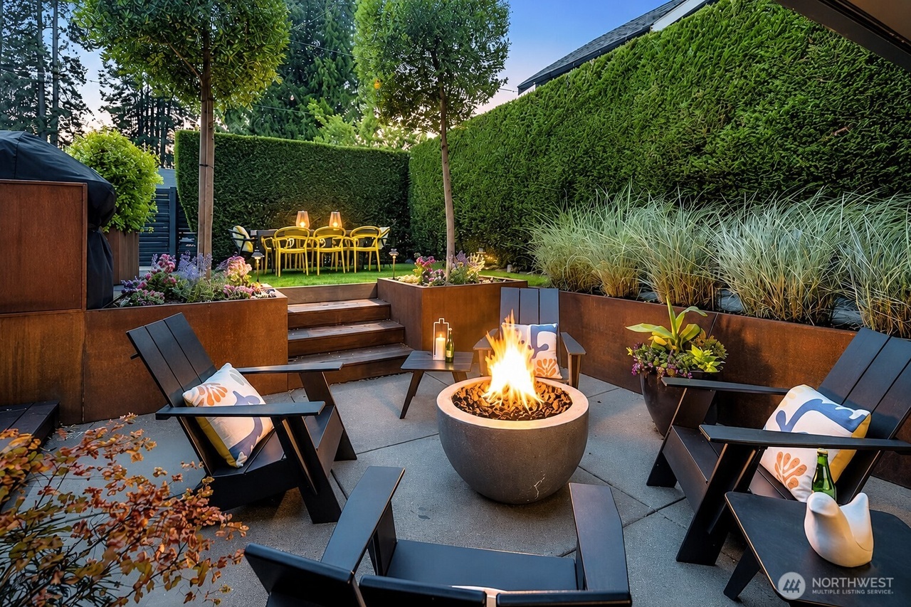 Outdoor patio with Adirondack chairs around a concrete fire bowl