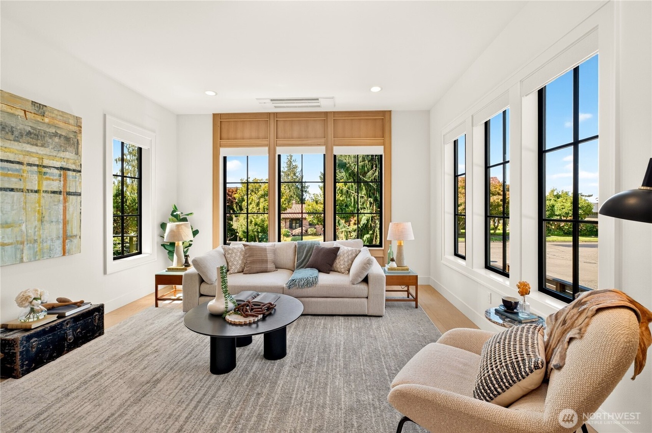 Sunlit contemporary living room with neutral sofa, sculptural black coffee table, and light wood trim