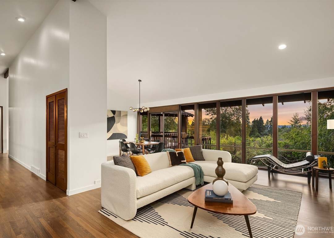 Mid-century modern living room with curved cream sectional sofa and floor-to-ceiling windows