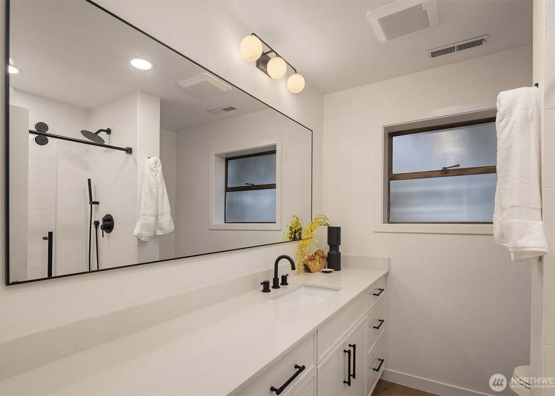 Contemporary bathroom with white vanity, black hardware, and walk-in shower