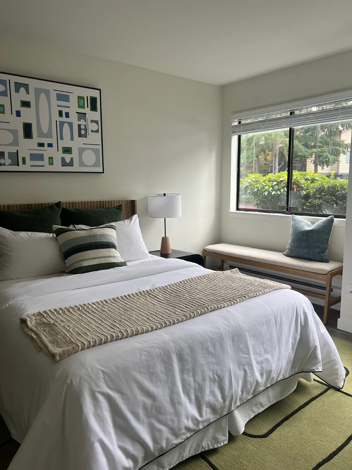The Park in Bellevue: Bedroom with fluted wood headboard and styled window bench