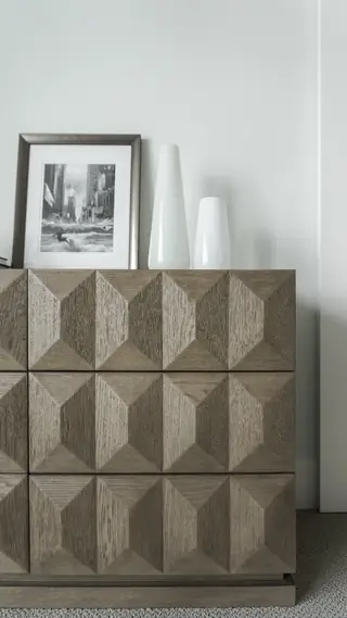 Wooden credenza with geometric drawer fronts styled with a framed print