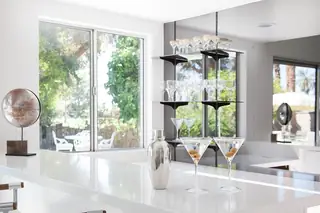 Pebble Beach Drive, Palm Springs: Two martini glasses with olives and a silver cocktail shaker rest on a glossy white counter in a modern home bar