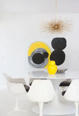 Pebble Beach Drive, Palm Springs: A bright mid-century modern dining space features a white tulip table with matching chairs, a brass sputnik chandelier