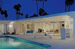 Turquoise swimming pool and mid-century modern house