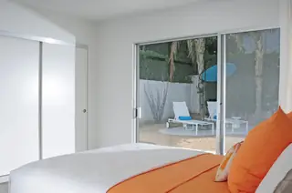 Minimalist bedroom with vibrant orange bedding