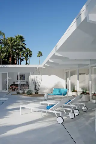 White mid-century modern patio with blue seating