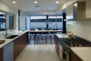The Aqua Lair, Lake Sammamish: A modern kitchen featuring dark wood cabinetry and a long counter bar
